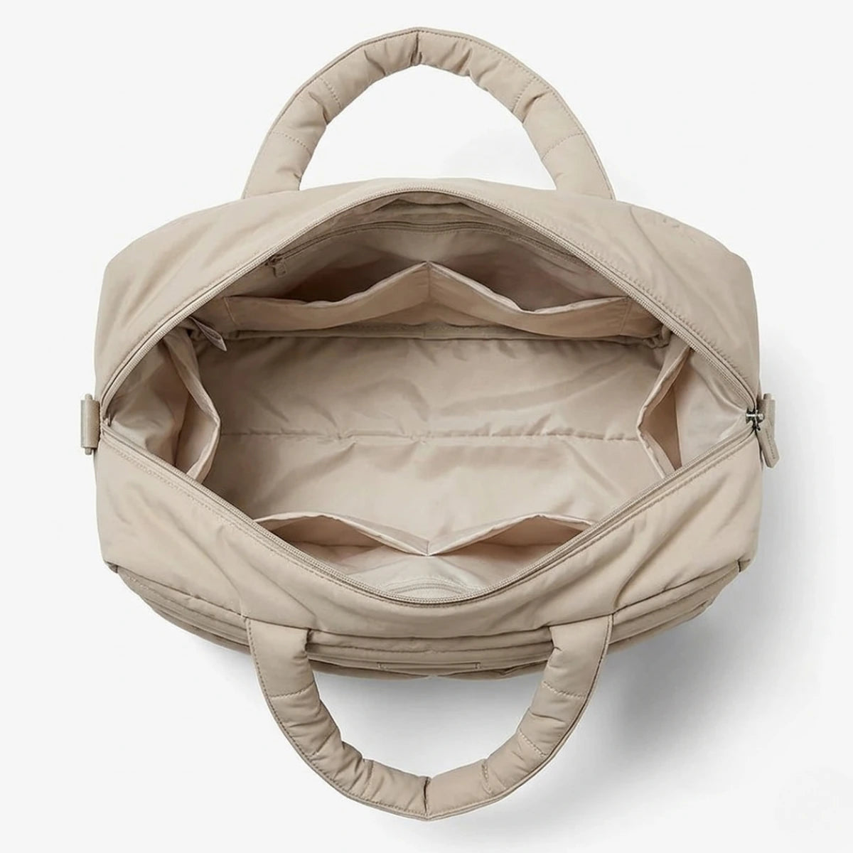 vue d'en haut de l'intérieur du grand sac à langer matelassé beige.