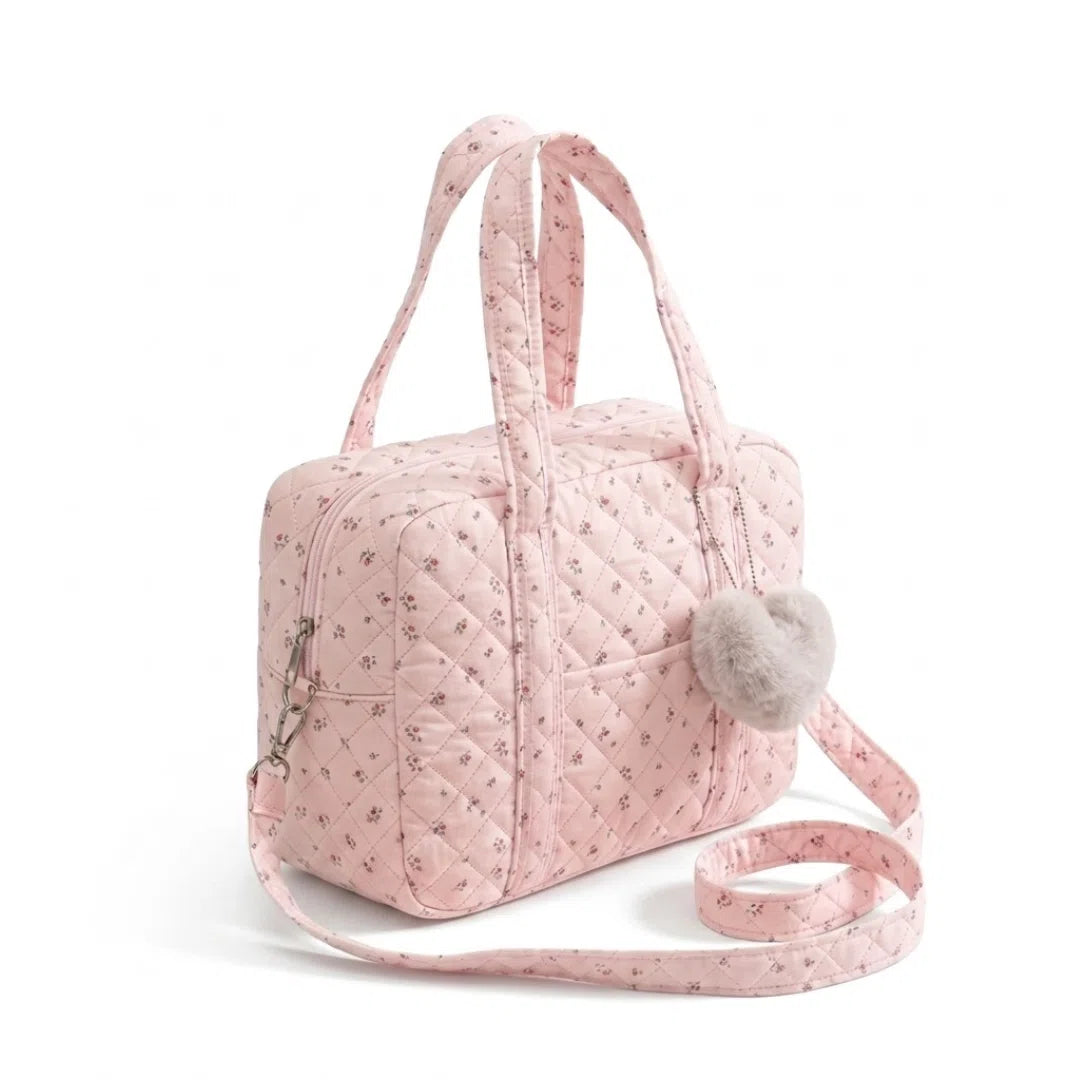Vue de 3/4 du sac à langer gaz de coton matelassé et coeur rose