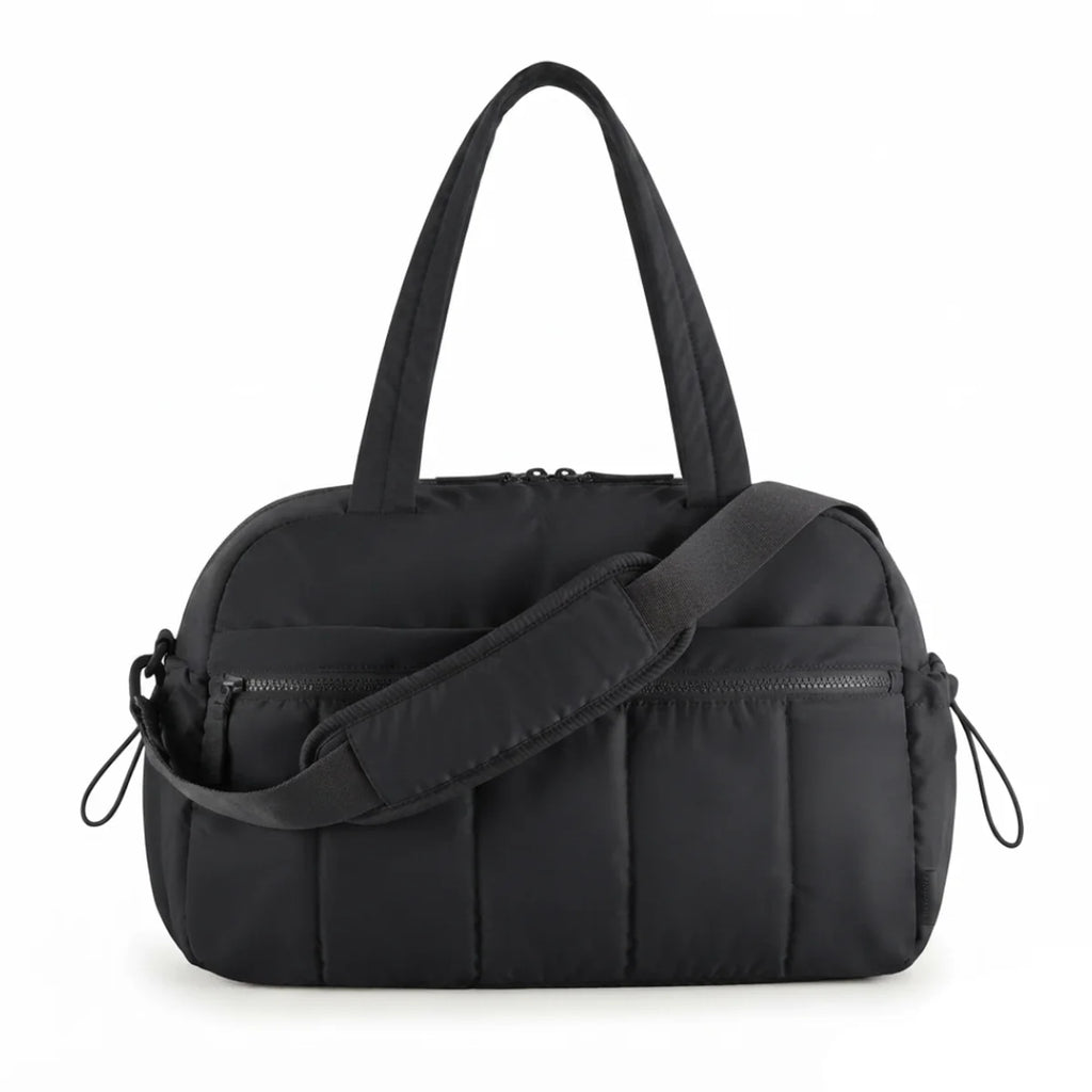 Vue du sac à langer déperlant matelassé coloris noir, vue de face avec bandoulière drapée devant.