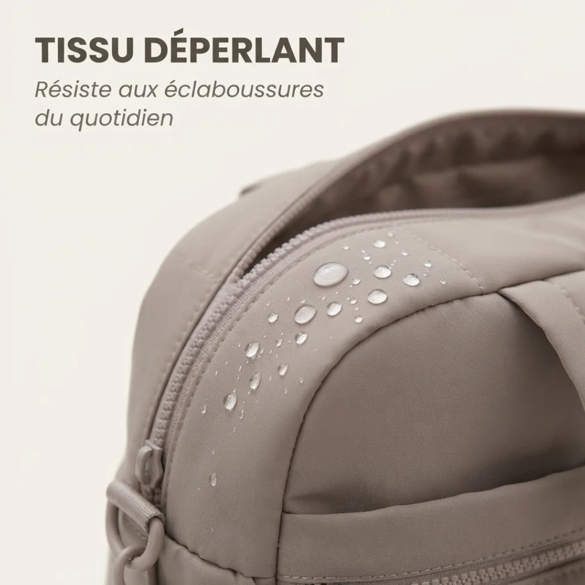 Vue du sac à langer déperlant matelassé en gros plan sur le coin près de la fermeture éclair, gouttes d'eau sur le tissu, infographie "Tissu déperlant".